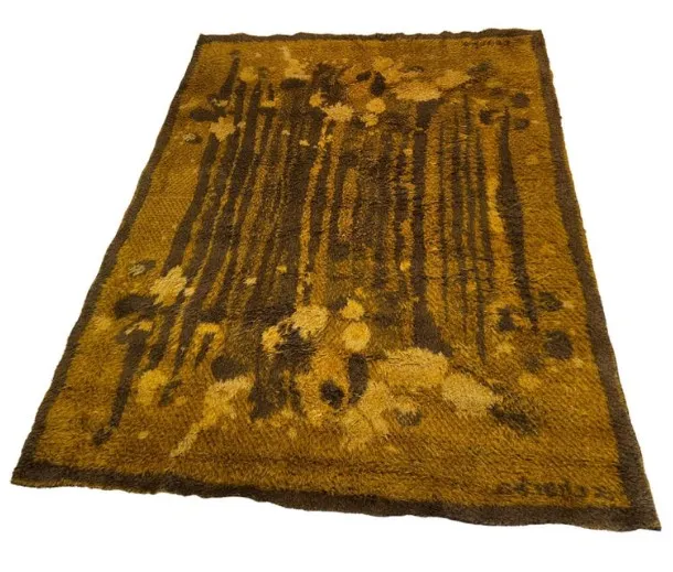 alfombra antigua con diseño en tonos marrones y amarillos