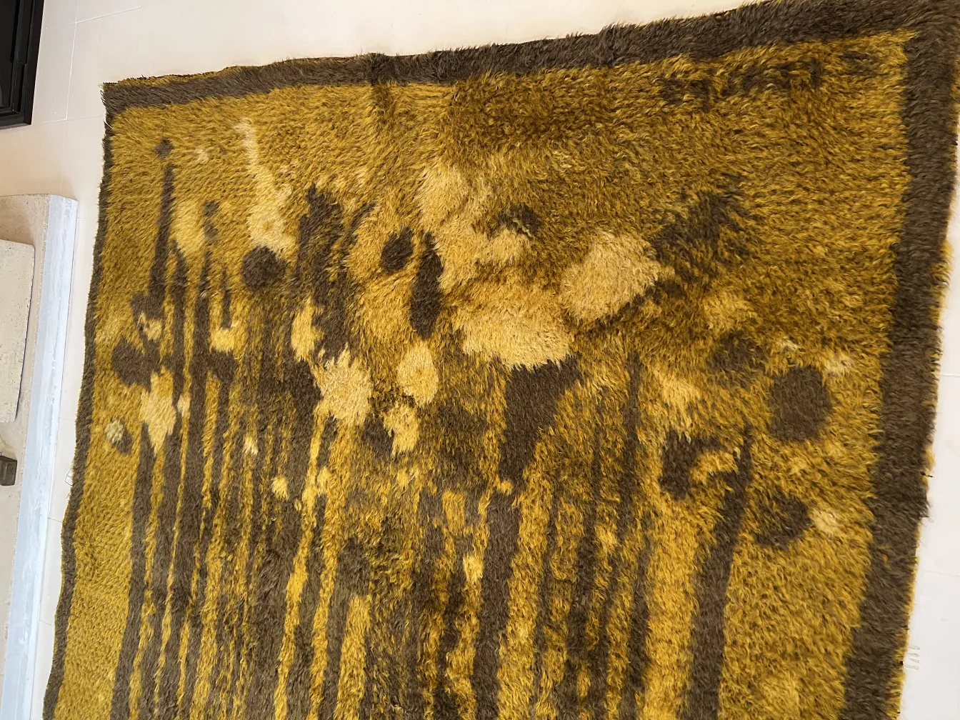 alfombra antigua con diseño floral en tonos amarillos y marrones