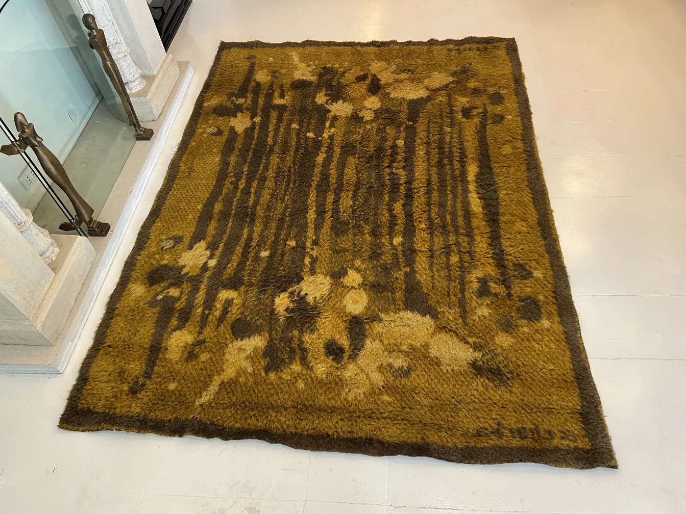 Tapis ancien aux teintes jaunes et brunes avec des motifs