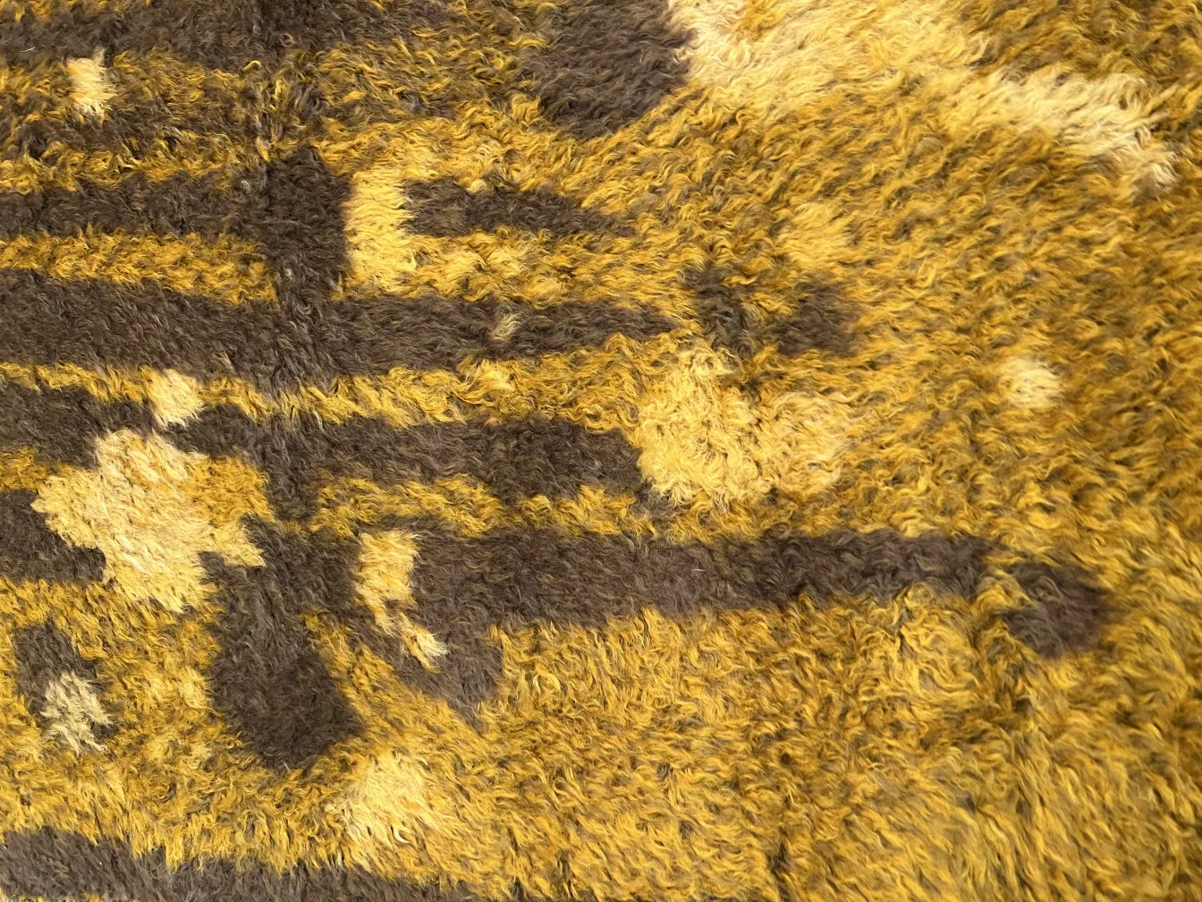 Tapis ancien avec des designs en tons chauds et des textures douces.