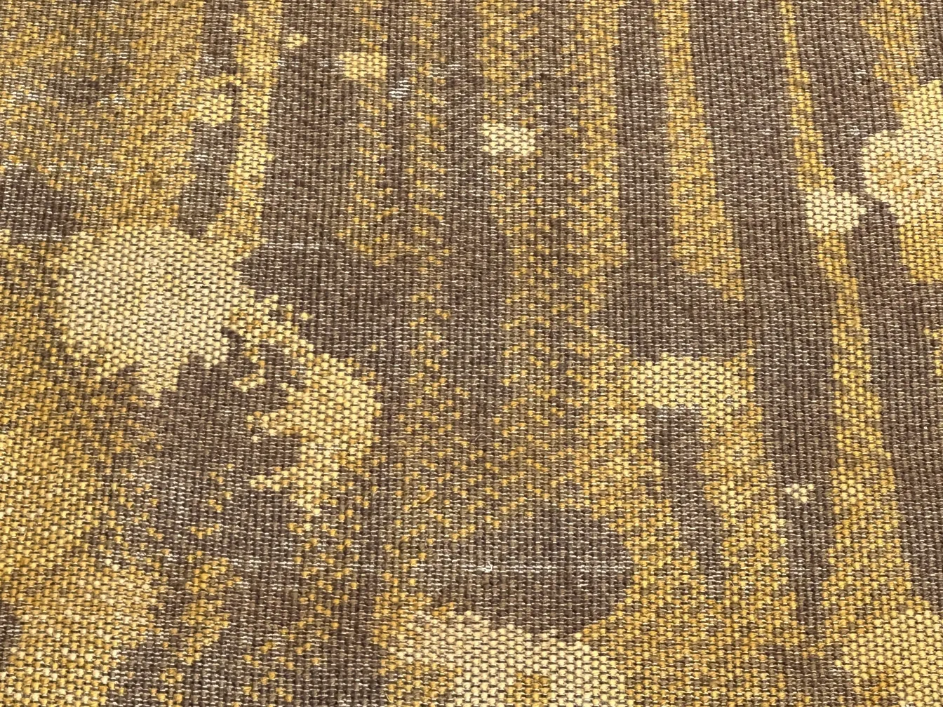 古いカーペットに茶色と黄色の斑点のパターンが施されています。