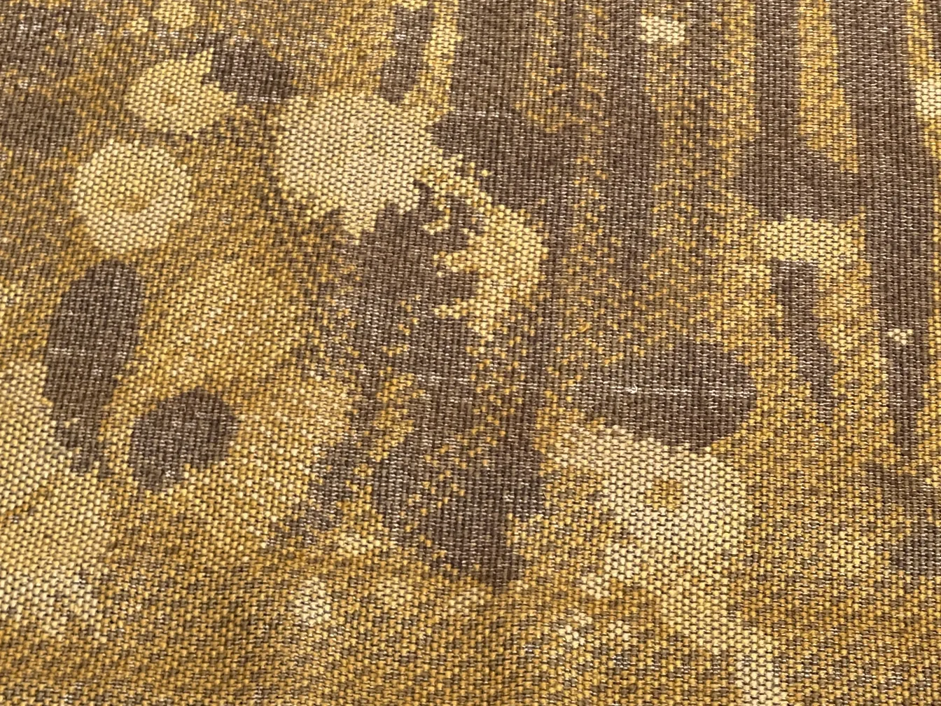 Antique carpet featuring unique design in brown and gold tones, cozy atmosphere.