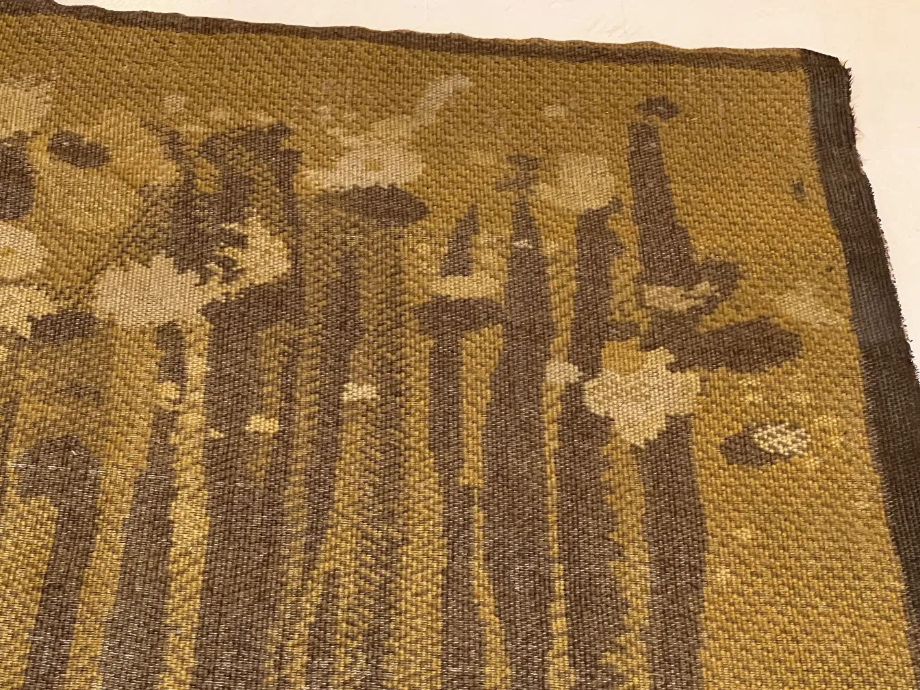 Antique carpet with floral design in brown and yellow tones, creating a cozy atmosphere.