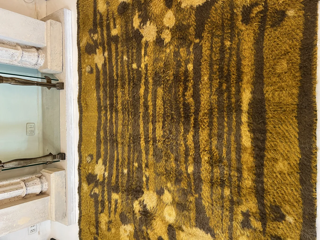 tapis ancien avec motif marron et jaune chaud dans un cadre