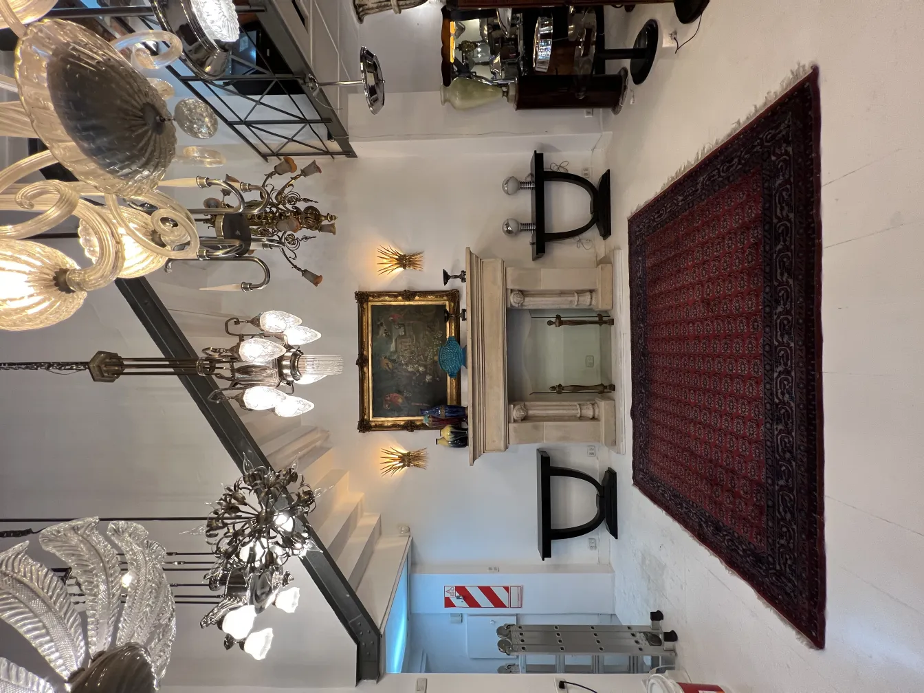 Antique red carpet enhancing room with elegant chandeliers.