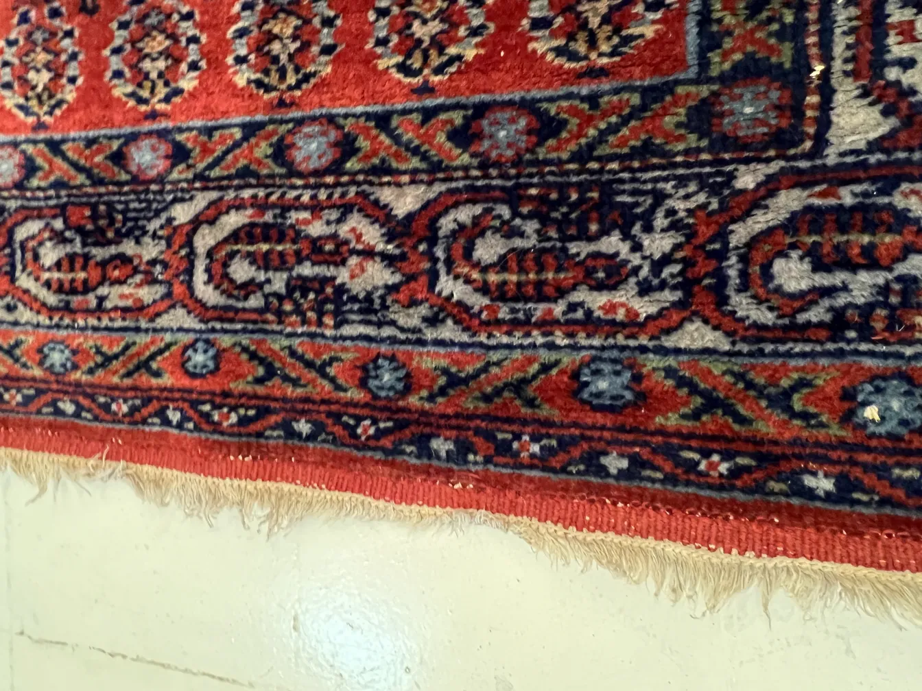 alfombra roja con patrones tradicionales y flecos dorados