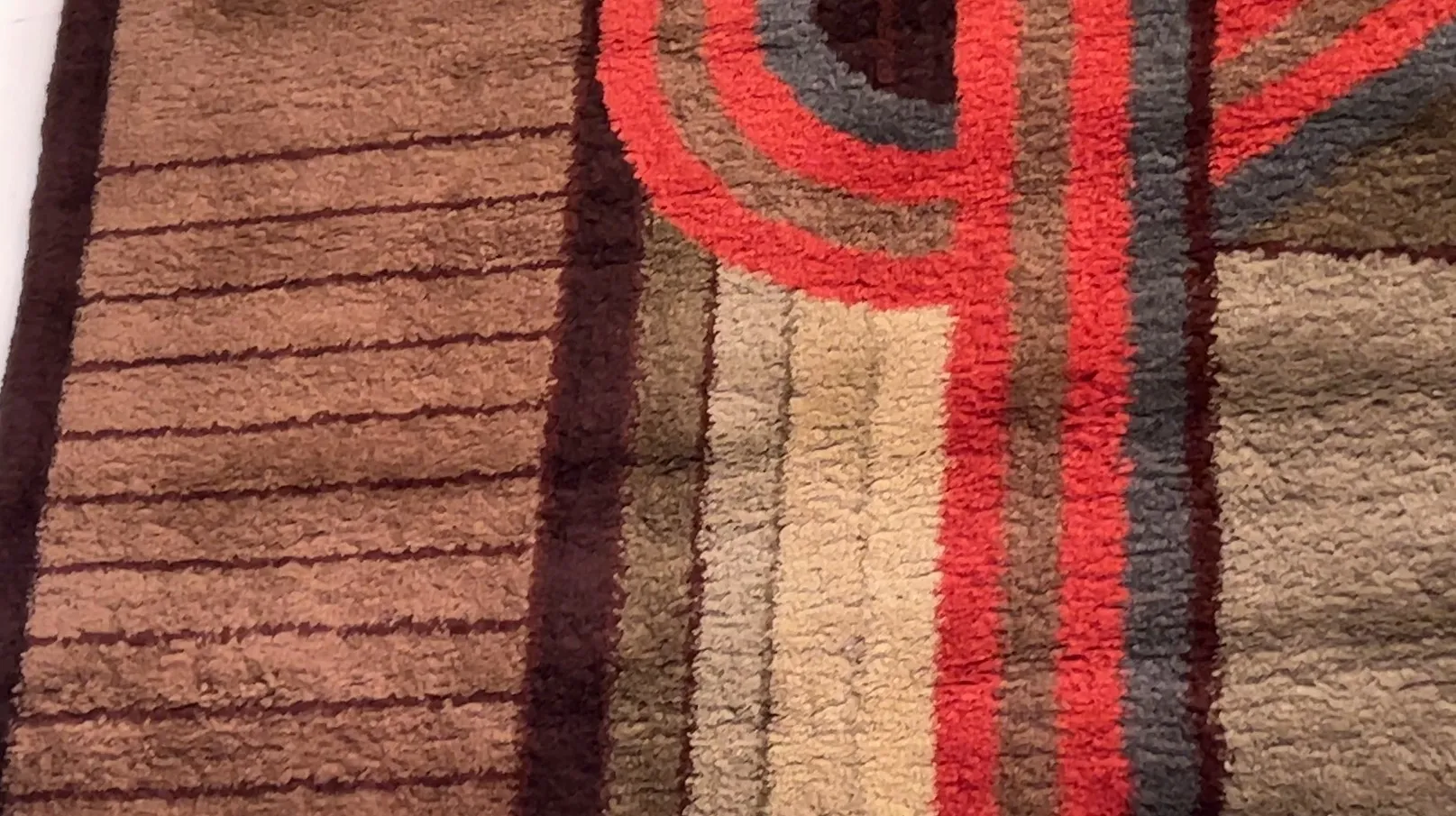 antique carpet with brown, red colors and abstract designs in a modern setting