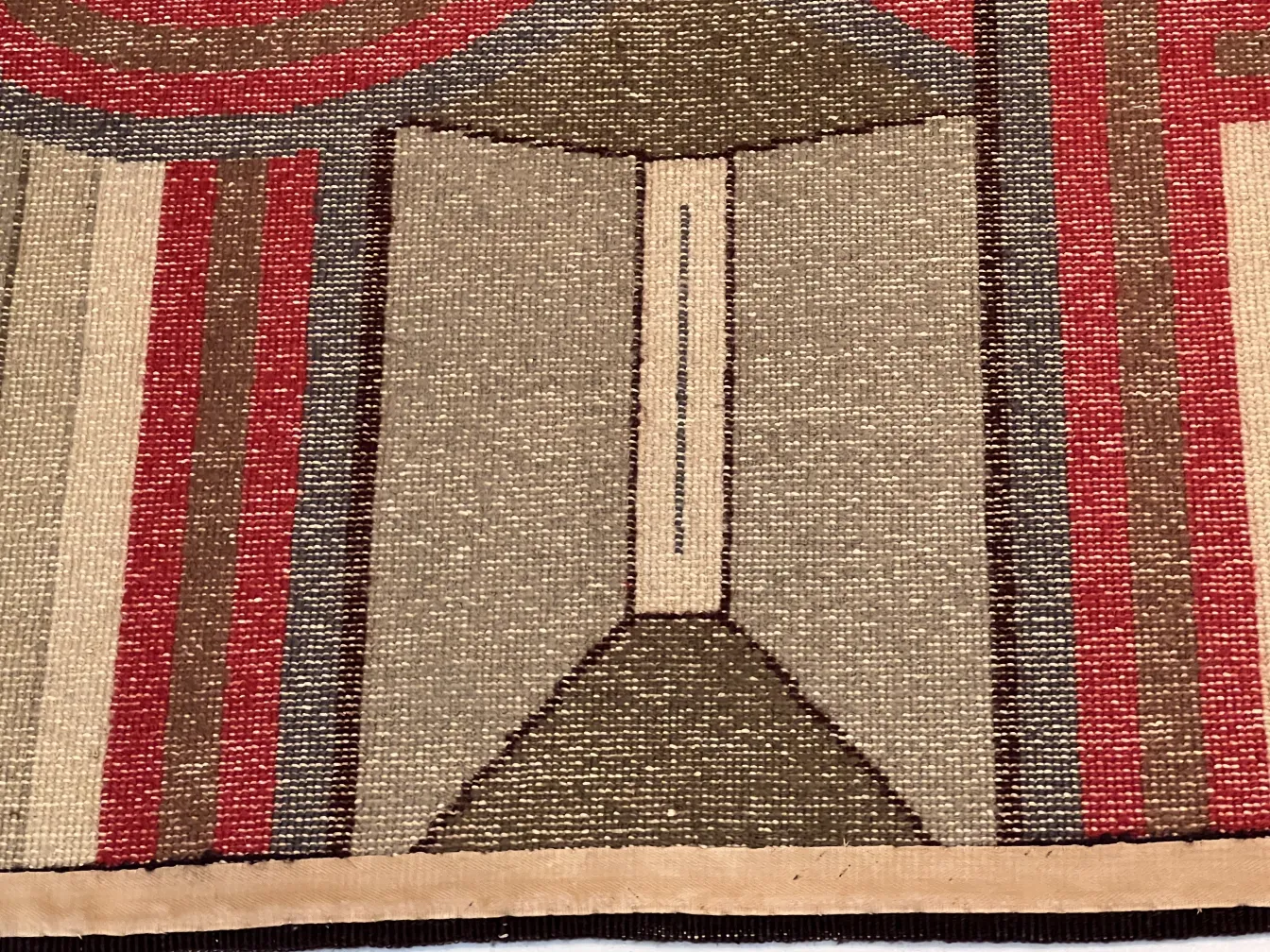 tapis ancien avec des motifs géométriques brun et rouge