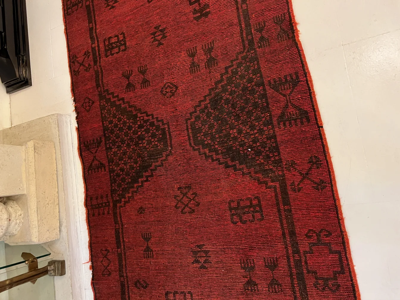 سجاد قديم باللون الأحمر مع أنماط في بيئة بسيطة