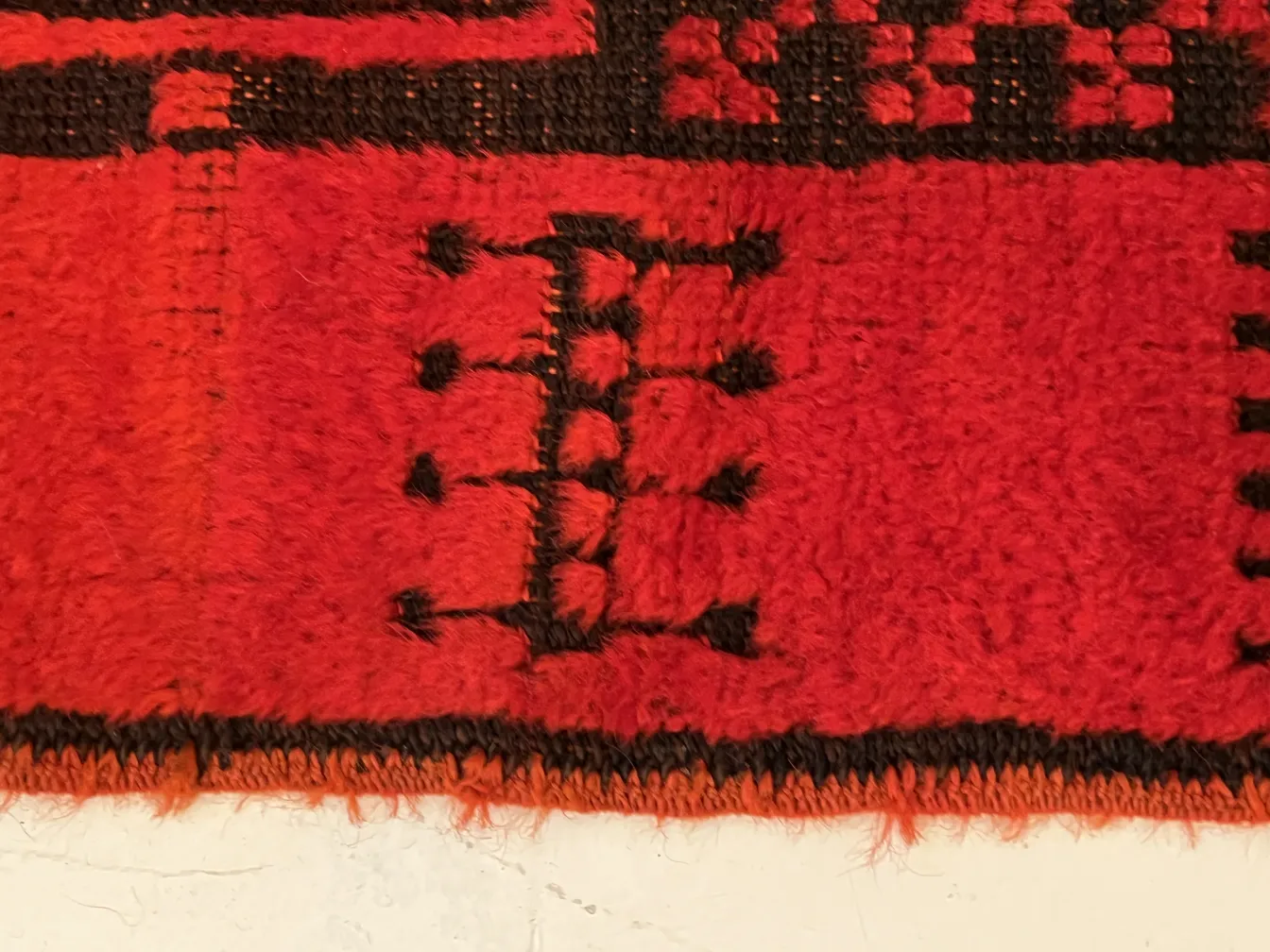 tapete antigo vermelho com padrões decorativos pretos