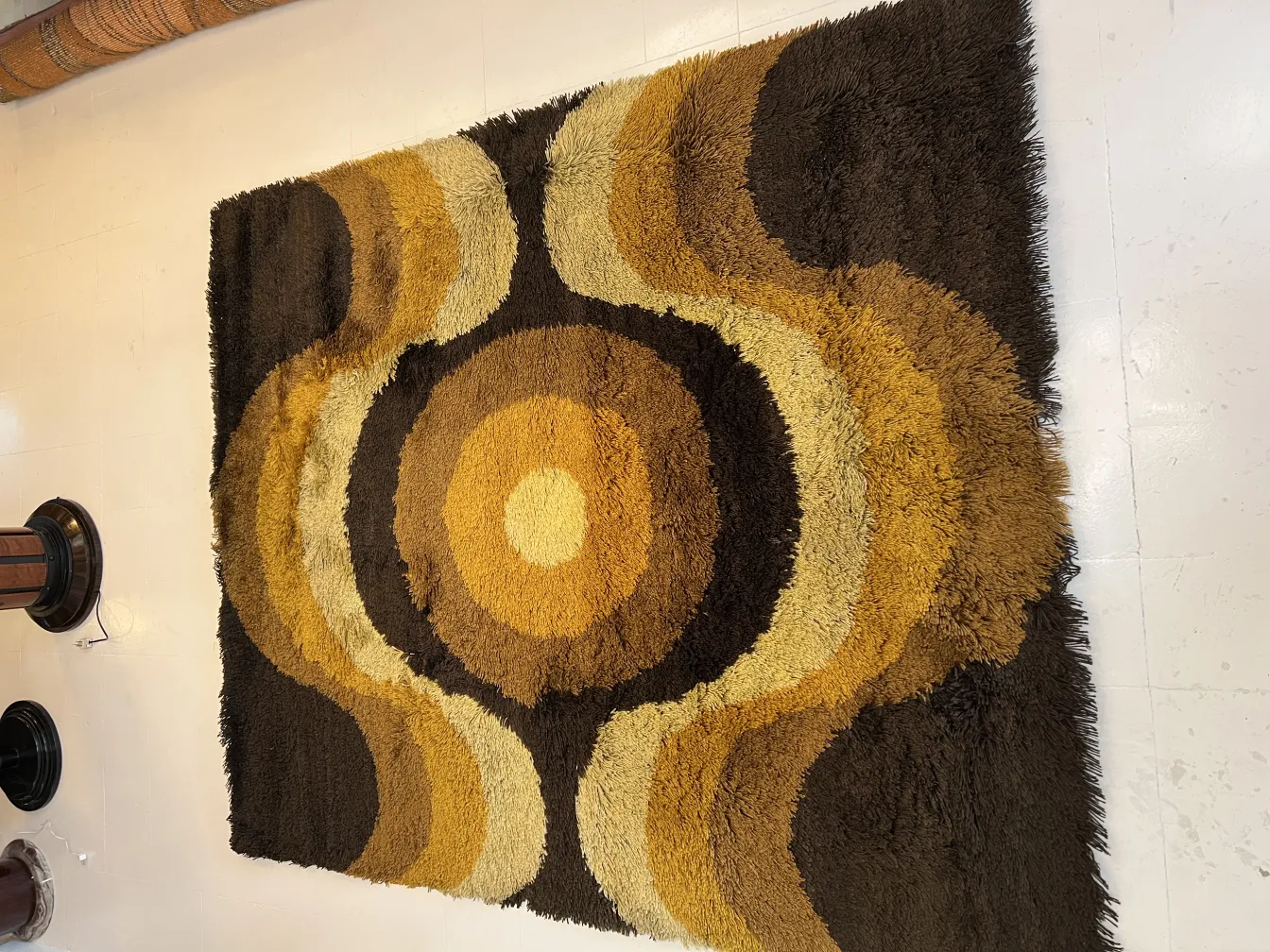 antique carpet featuring circular patterns in earthy tones