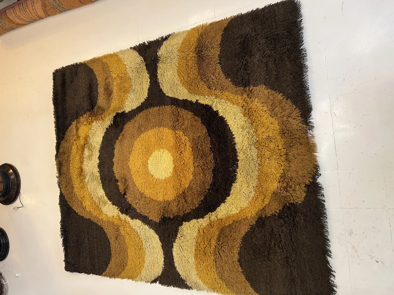antique carpet with circular designs in brown and yellow tones