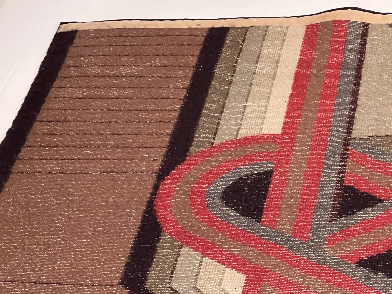 tapete antigo com padrões geométricos em marrom e vermelho, em ambiente elegante