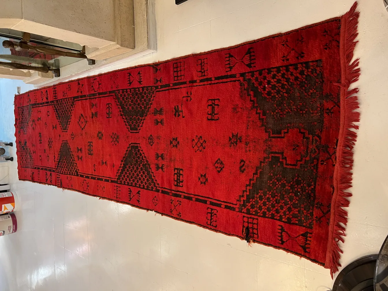 tappeto antico rosso con motivi geometrici in un contesto moderno