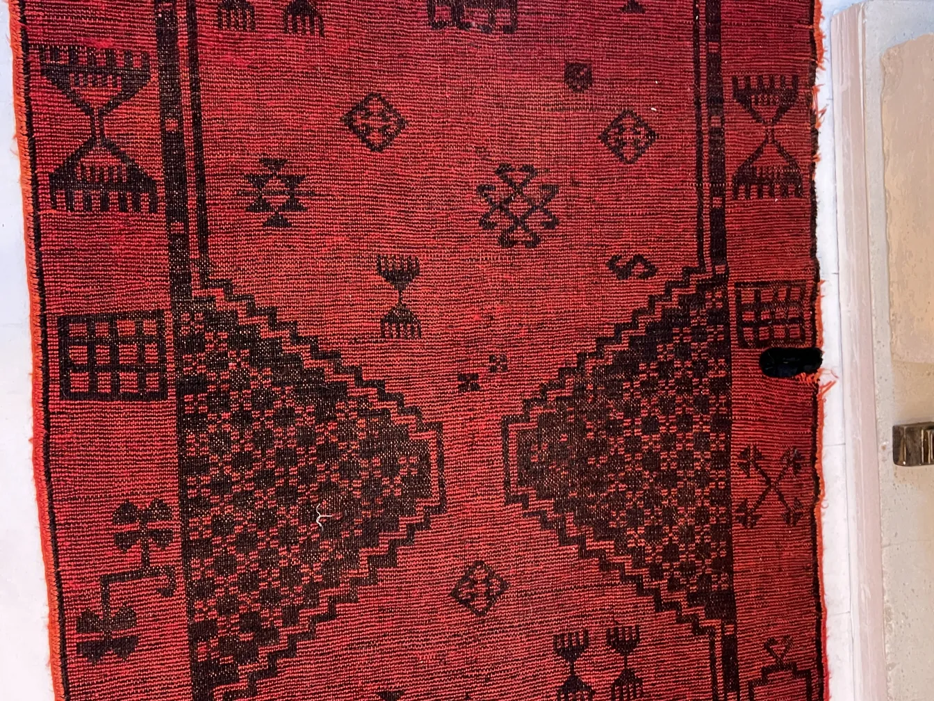 alfombra antigua roja con patrones decorativos en negro