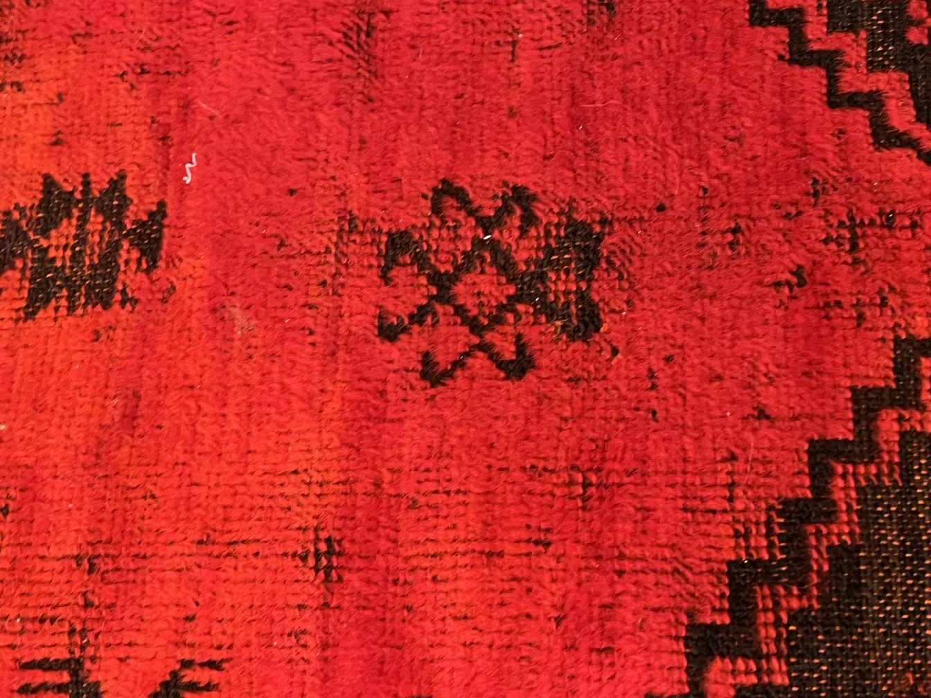 antique carpet in red and black tones with patterns