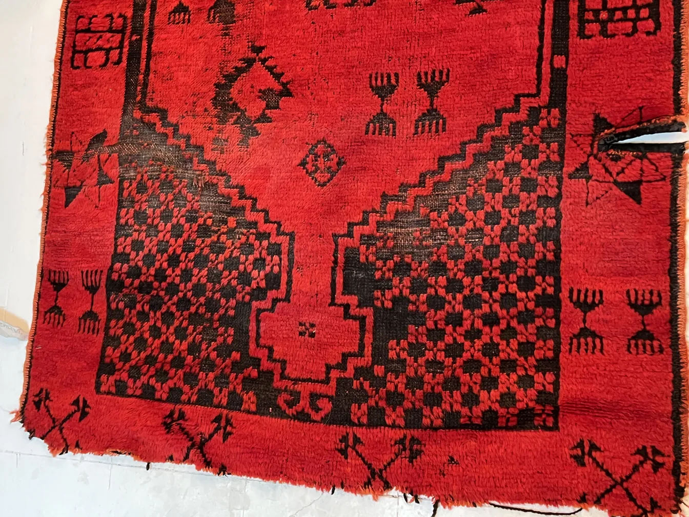 alfombra antigua roja y negra con diseños geométricos, ideal para decoración