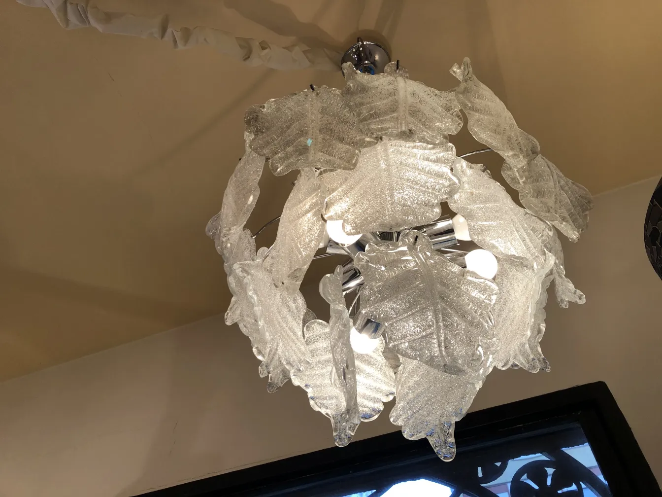 Duas lampadas de teto antigas em forma de folhas, iluminando o ambiente