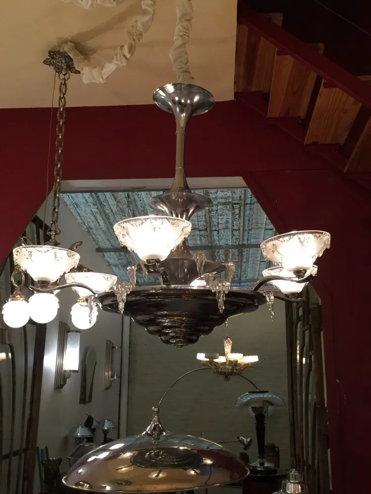 Antiga lâmpada de teto com detalhes brilhantes em um ambiente clássico.