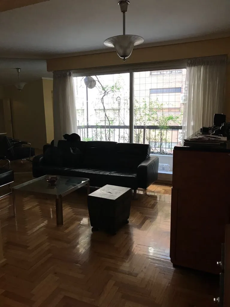 Vista de 2 lampadas de teto antigas em uma sala com sofá e mesa de centro.