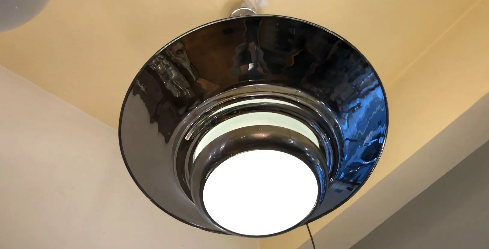 Visão de duas lâmpadas de teto antigas, elegantemente desenhadas, em um ambiente aconchegante