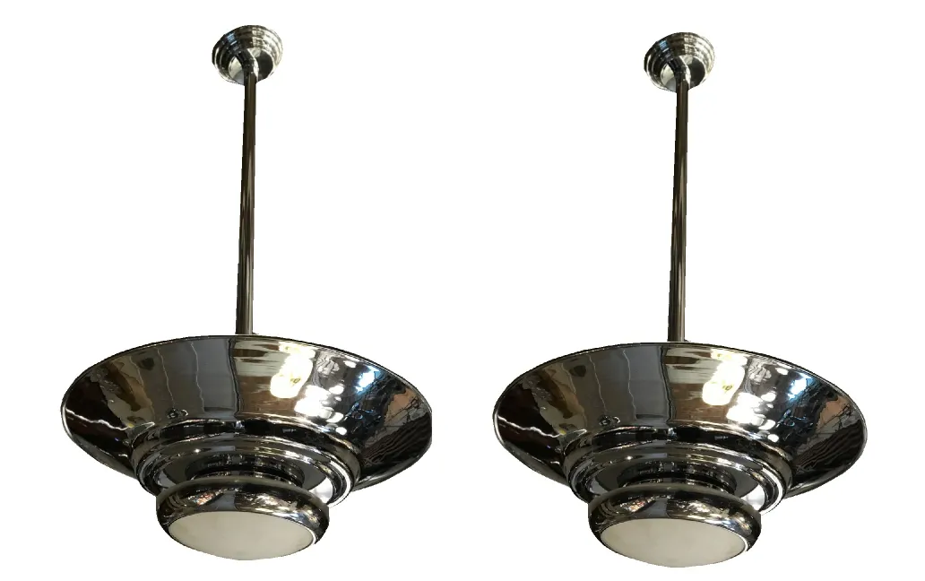 duas lampadas de teto antigas com design metálico brilhante e cúpulas largas, iluminando um espaço