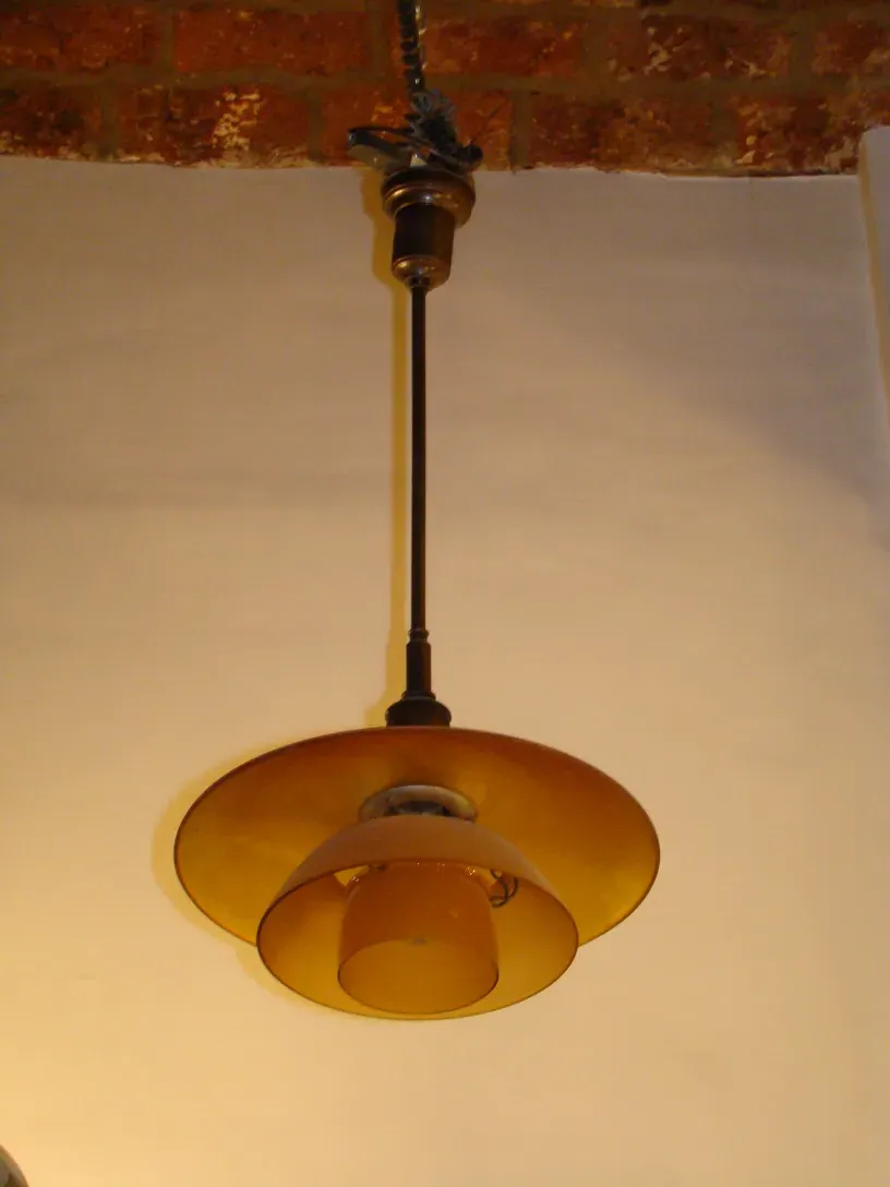 duas lampadas de teto antigas com design exclusivo de Poul Henningsen, iluminando um espaço aconchegante