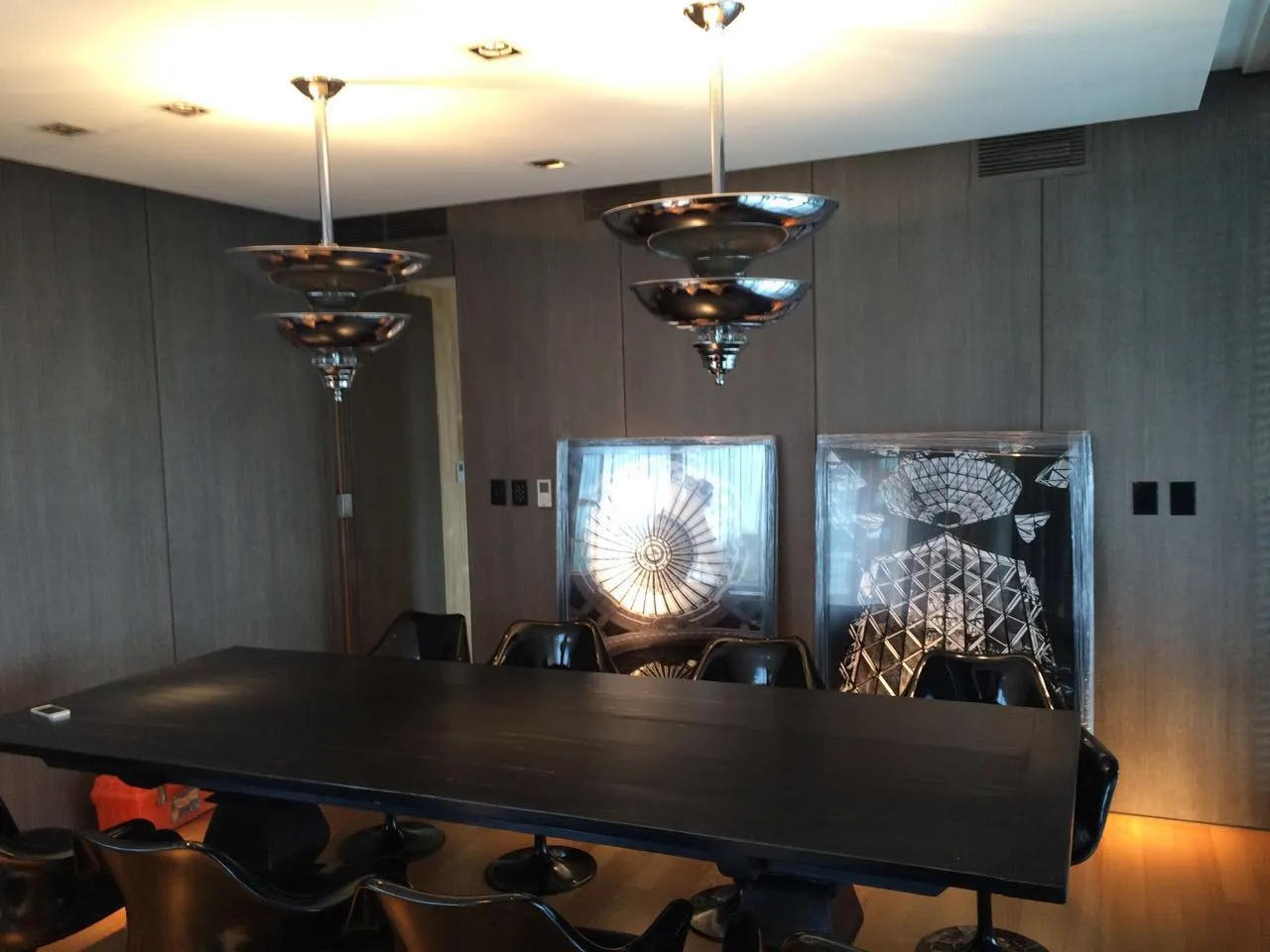 Interior com 2 lâmpadas de teto antigas e uma mesa grande