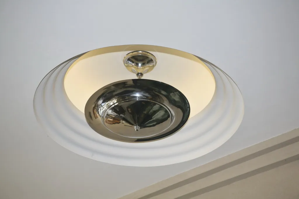 Vista dettagliata di 2 lampade a sospensione antiche in forma circolare, collocate in un ambiente moderno.