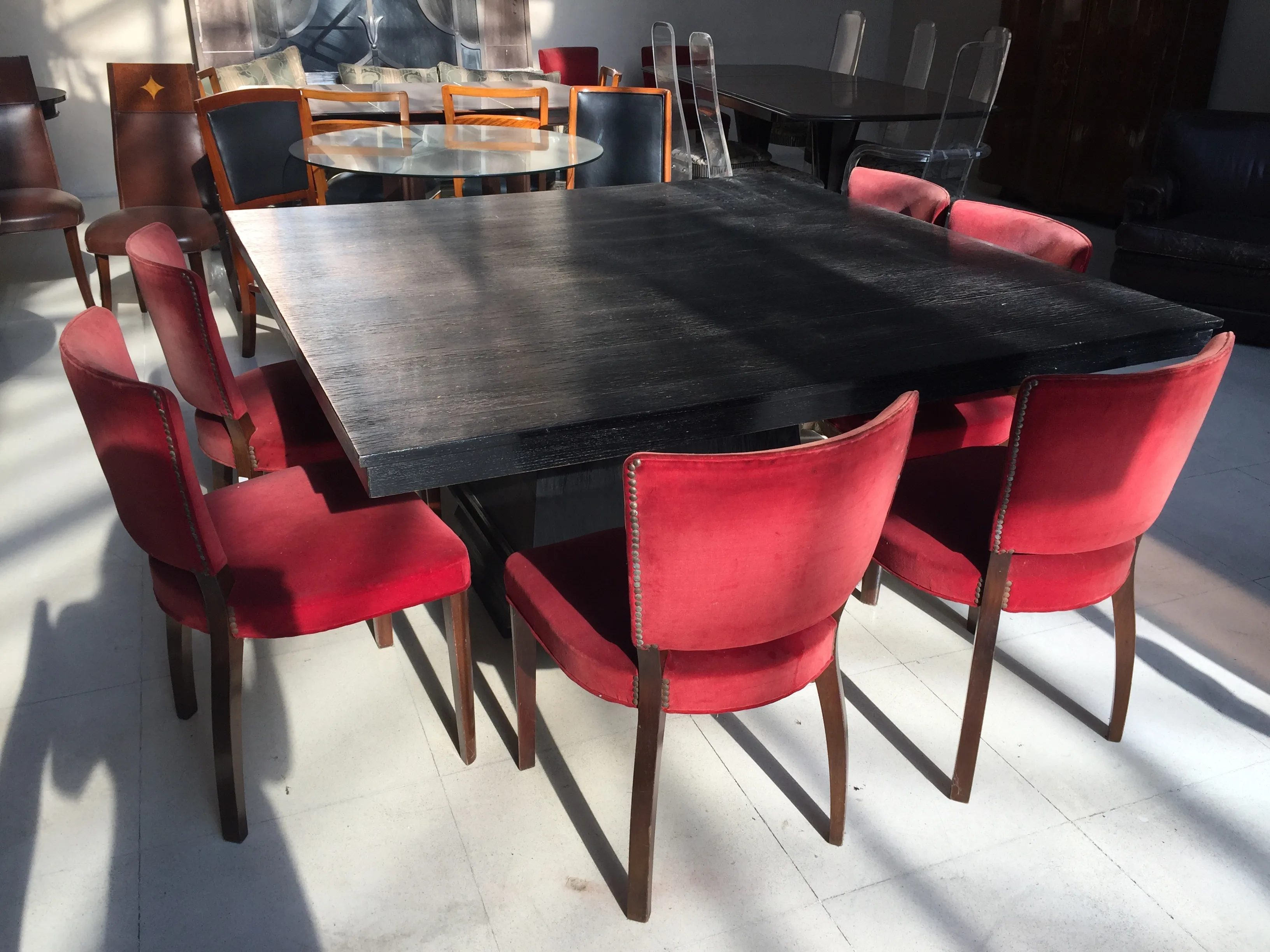 Table à manger ancienne pour 8 personnes avec des chaises rouges. Ambiance chaleureuse.