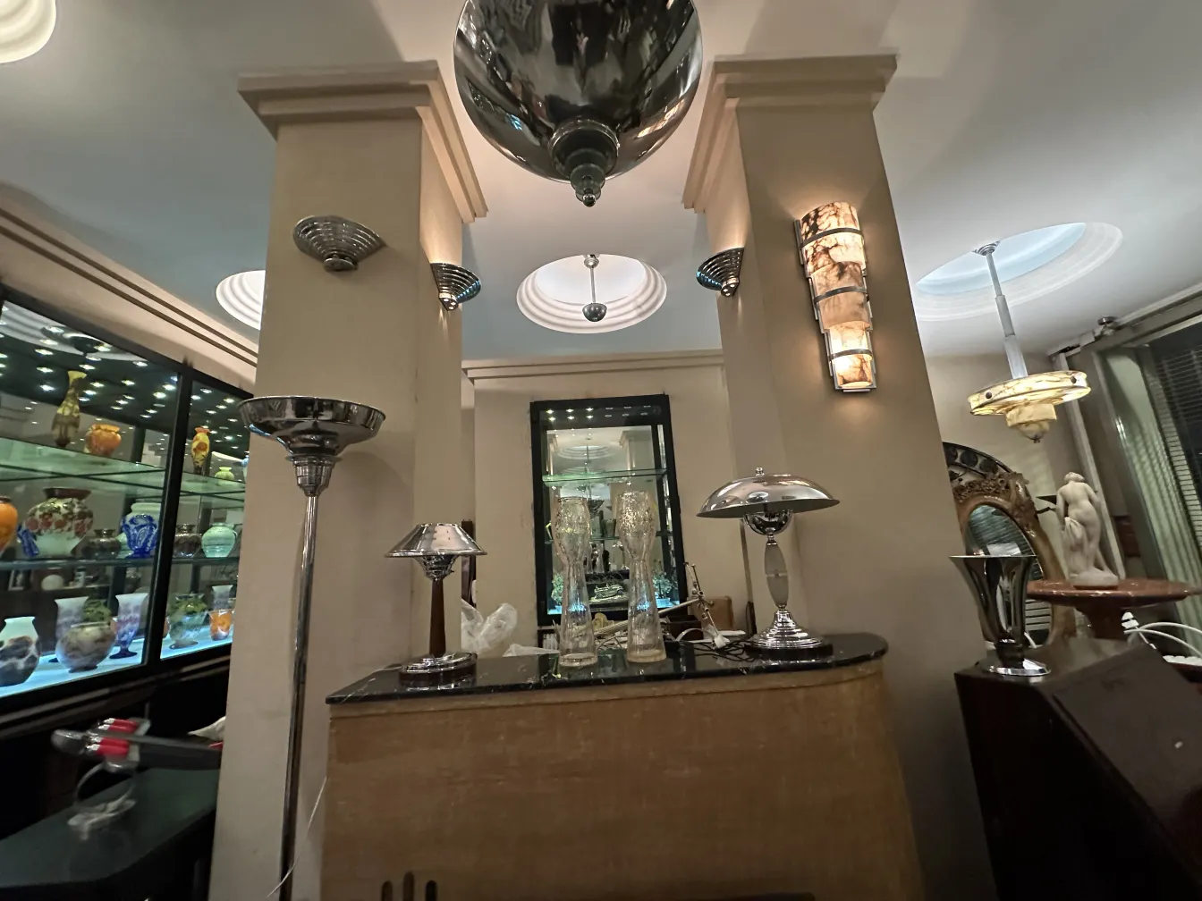 Dos lámparas de techo antiguas con diseño elegante en ambiente decorativo, rodeadas de otros objetos decorativos