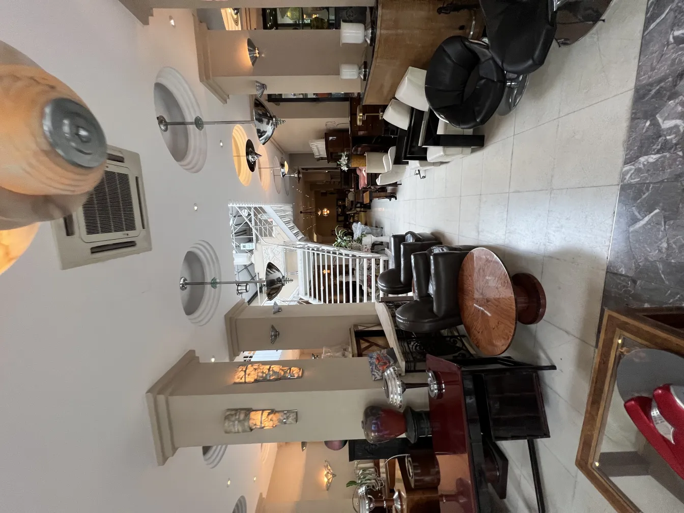 Vue de 2 lustres anciens dans un salon chaleureux avec des meubles élégants.