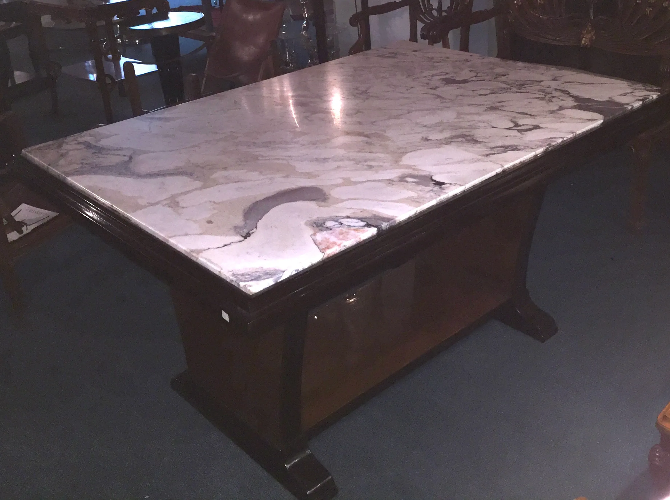 mesa de comedor antigua art deco con superficie detallada y patas elegantes, entorno clásico.