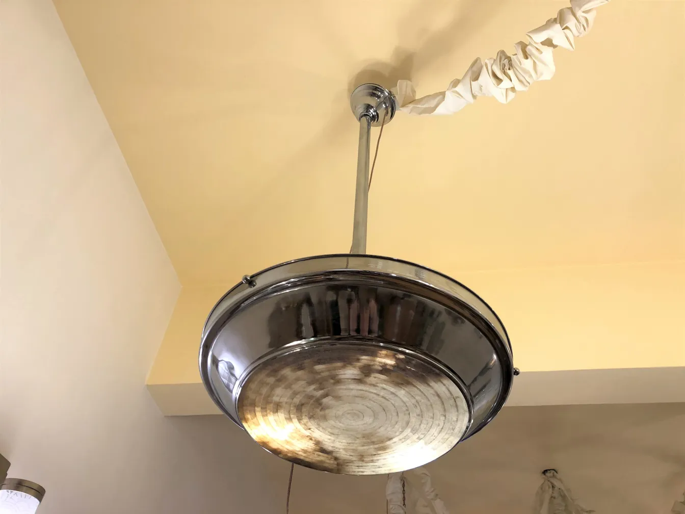 Top view of 2 antique round hanging lamps in a warm setting.