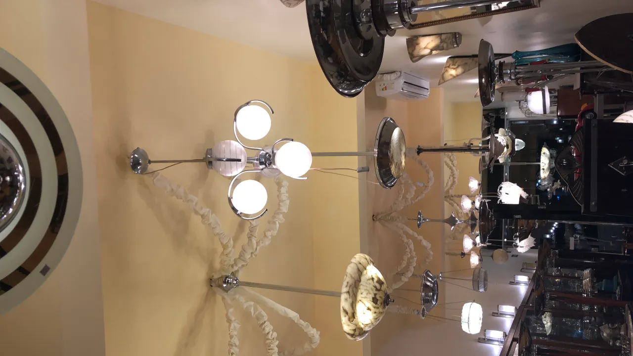 Two antique hanging lamps with bright, elegant lights in a cheerful setting.