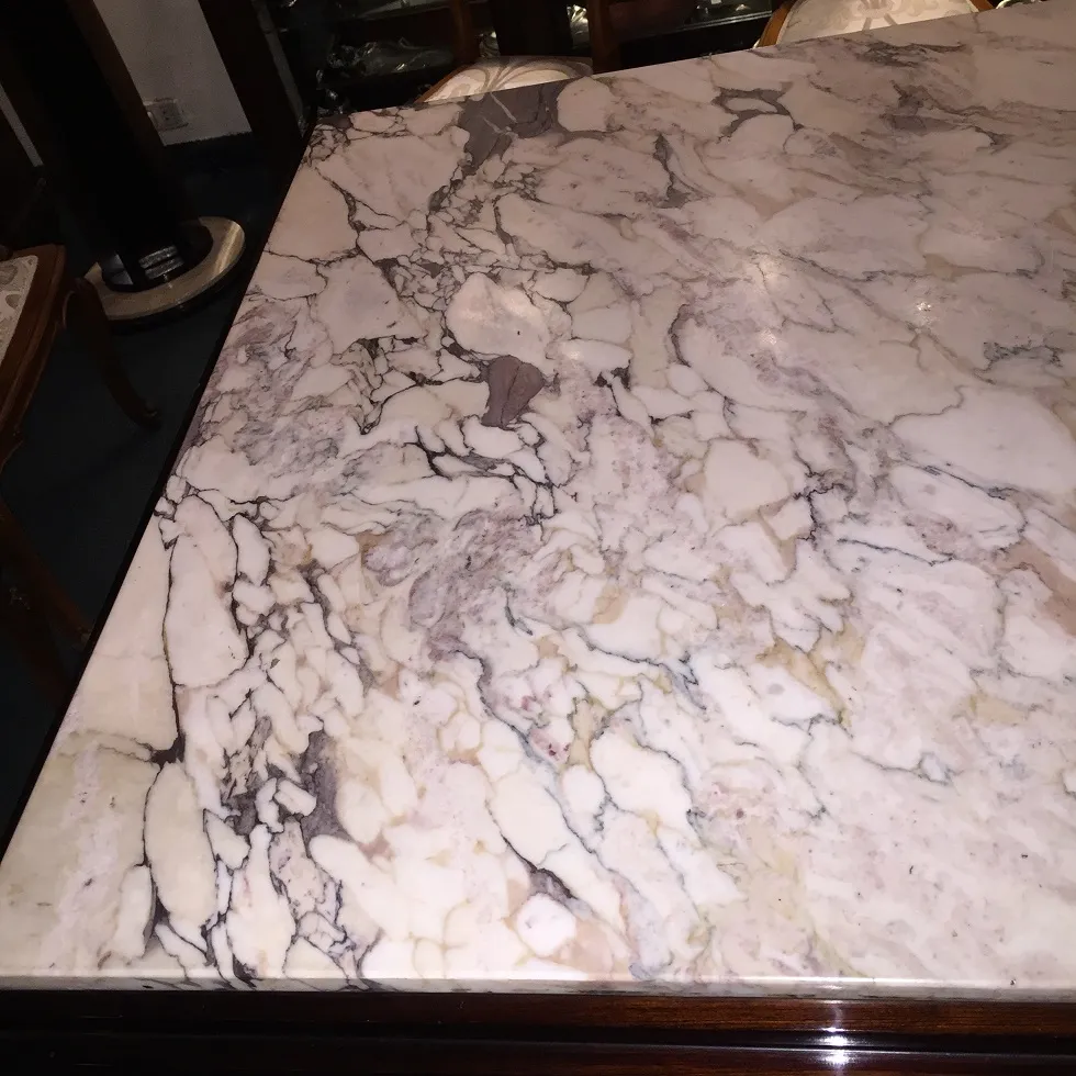 Table à manger ancienne avec plateau en marbre, design élégant.