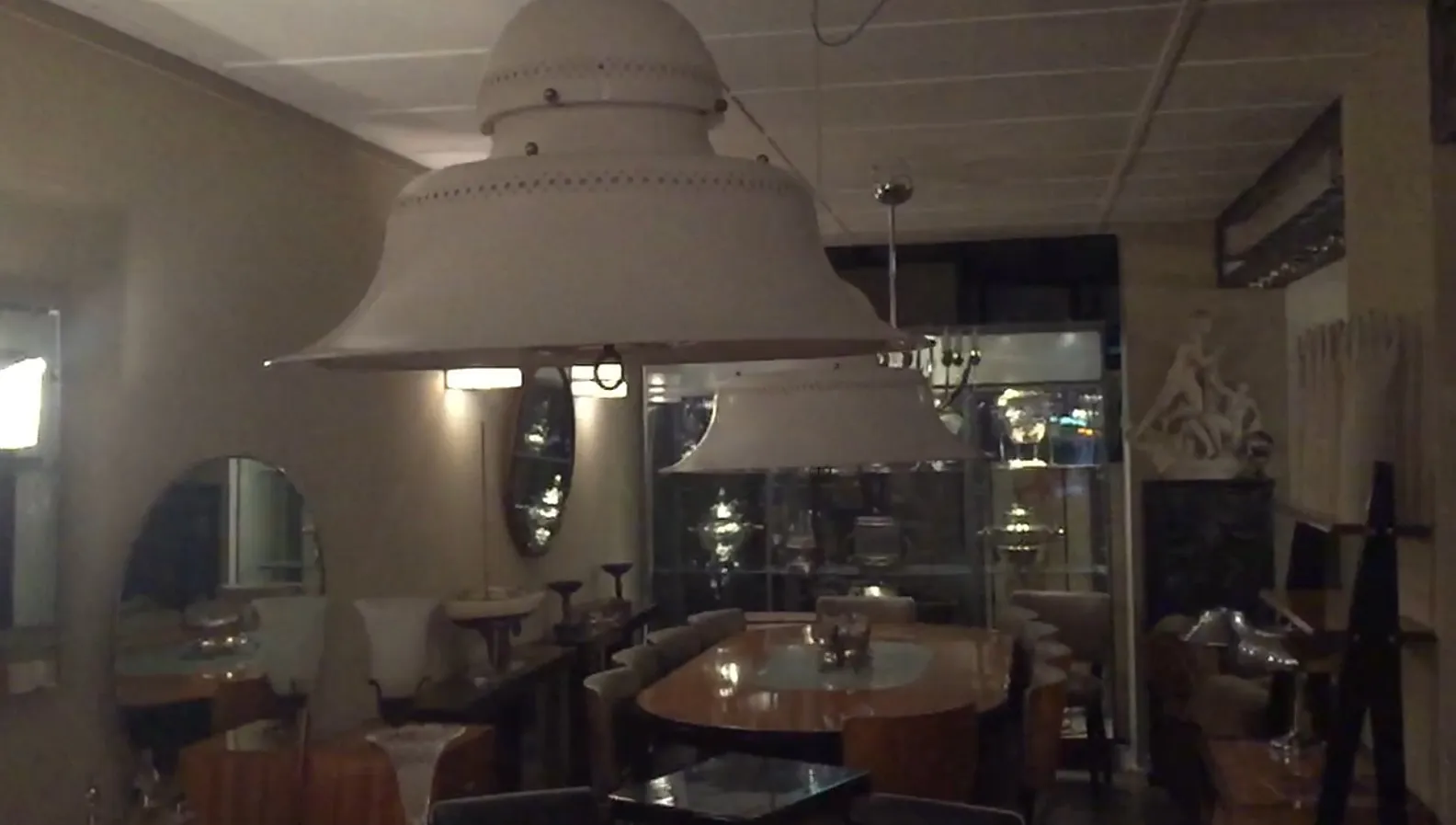 due lampade a sospensione antiche in una sala da pranzo elegante, circondate da decorazioni classiche