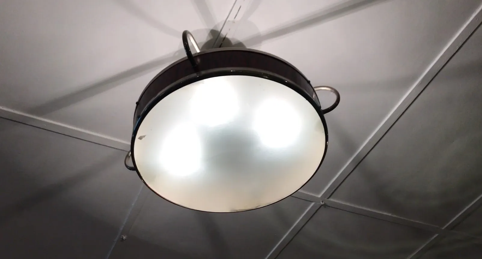 Duas lâmpadas de teto antigas de design circular, decorando um espaço moderno.