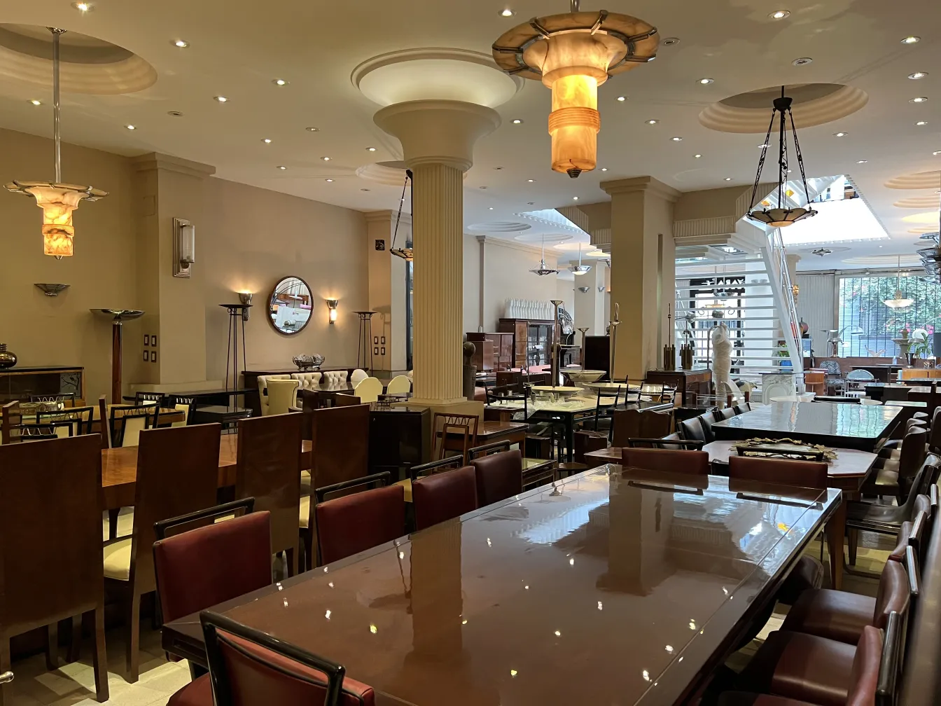 Ambiente com 2 lampadas de teto antigas e mesas elegantes