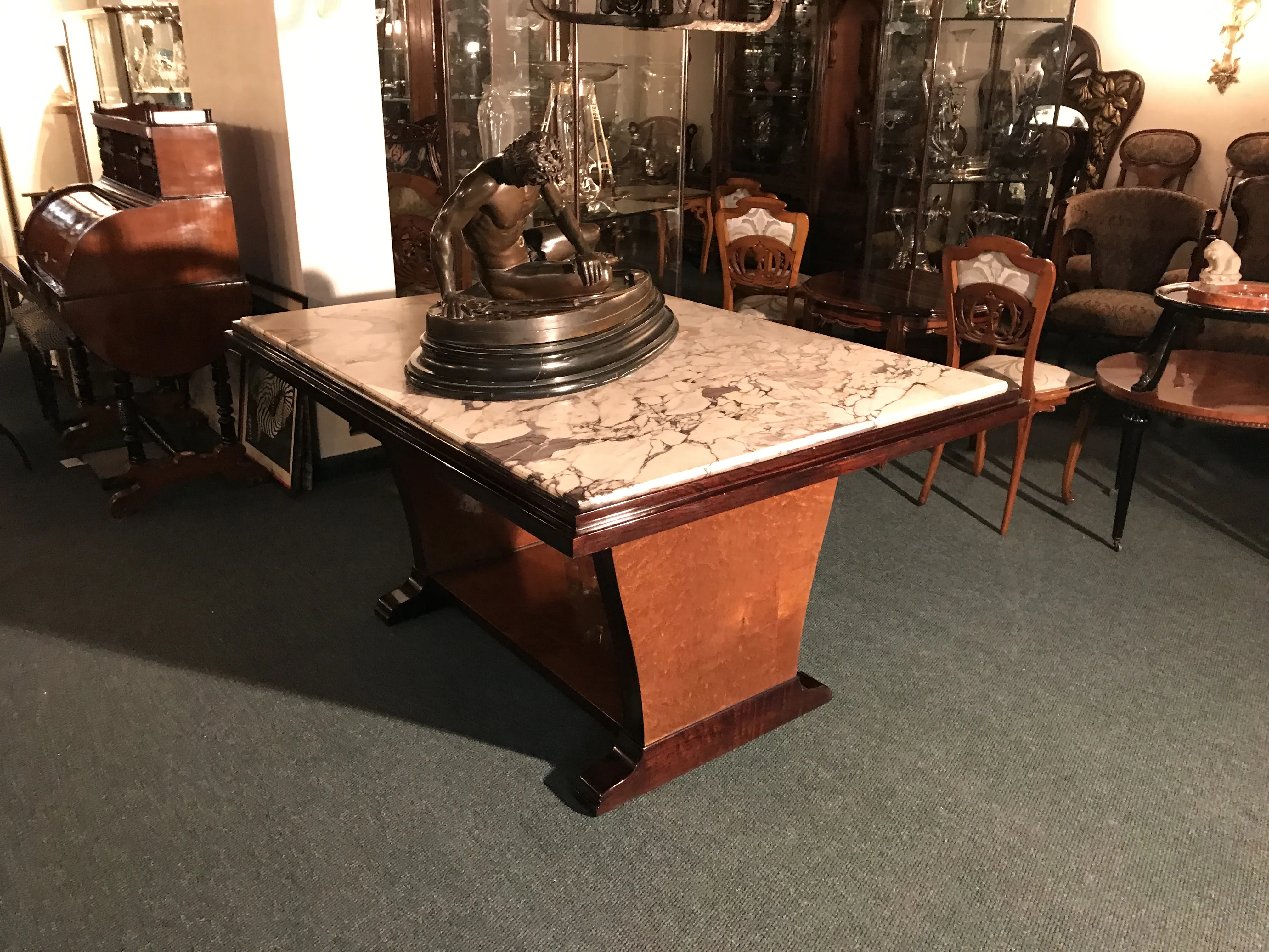 Antique dining table in Art Deco style, with decorative base and cozy ambiance.