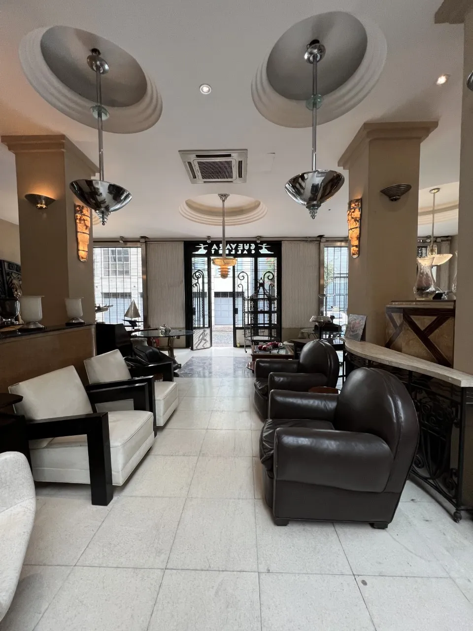 2 lampadas de teto antigas em um ambiente elegante com poltronas.