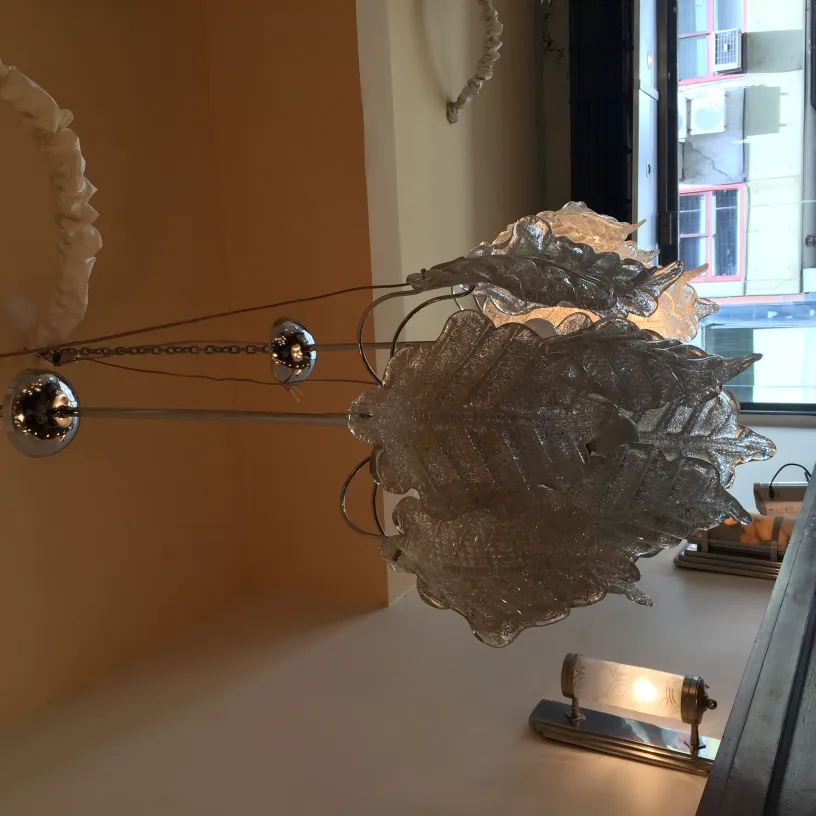 due lampade a sospensione antiche a forma di foglia con dettagli lucidi, appese in una stanza illuminata