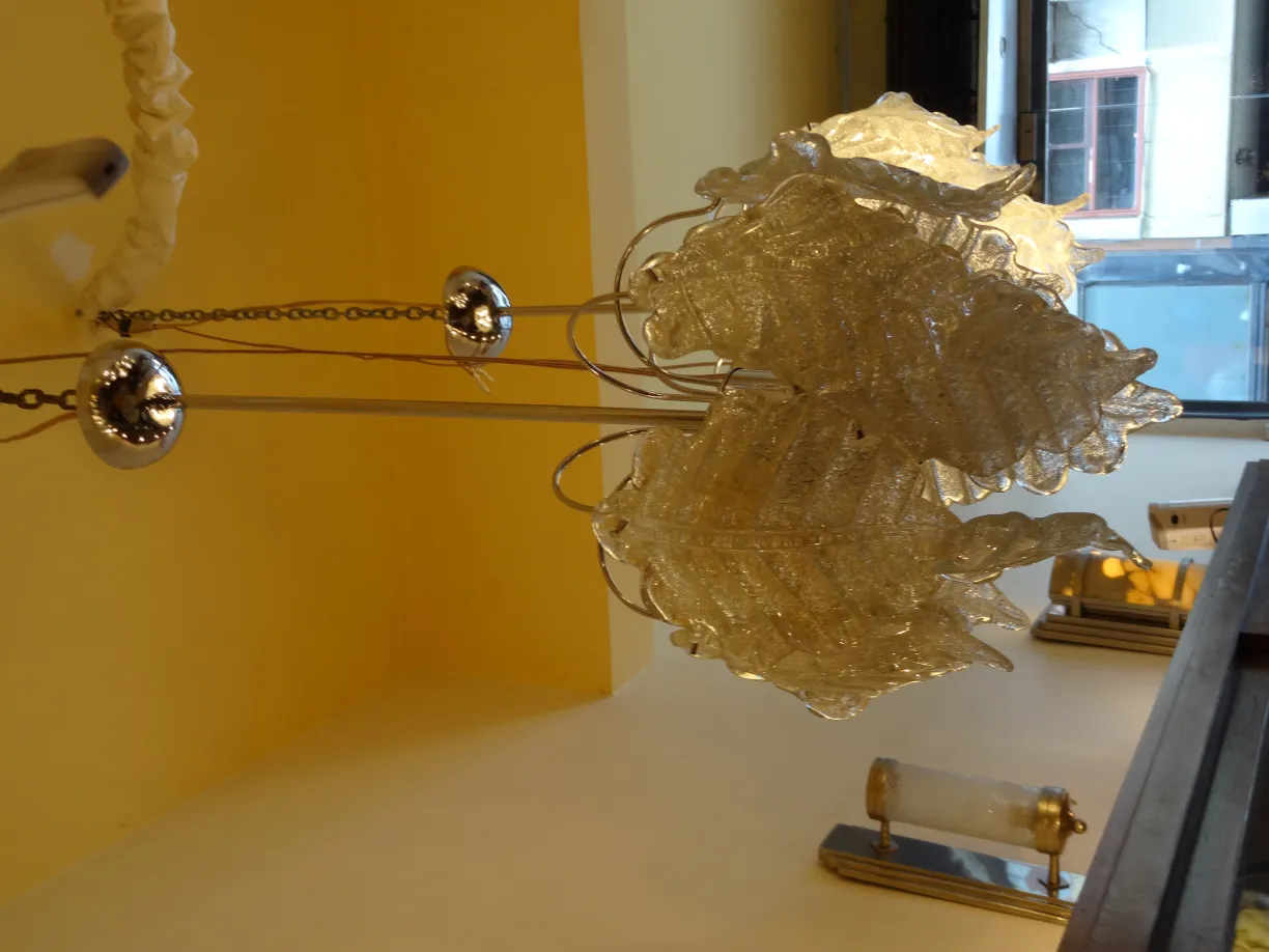 2 lampade a sospensione antiche con design a foglia, in un ambiente luminoso.