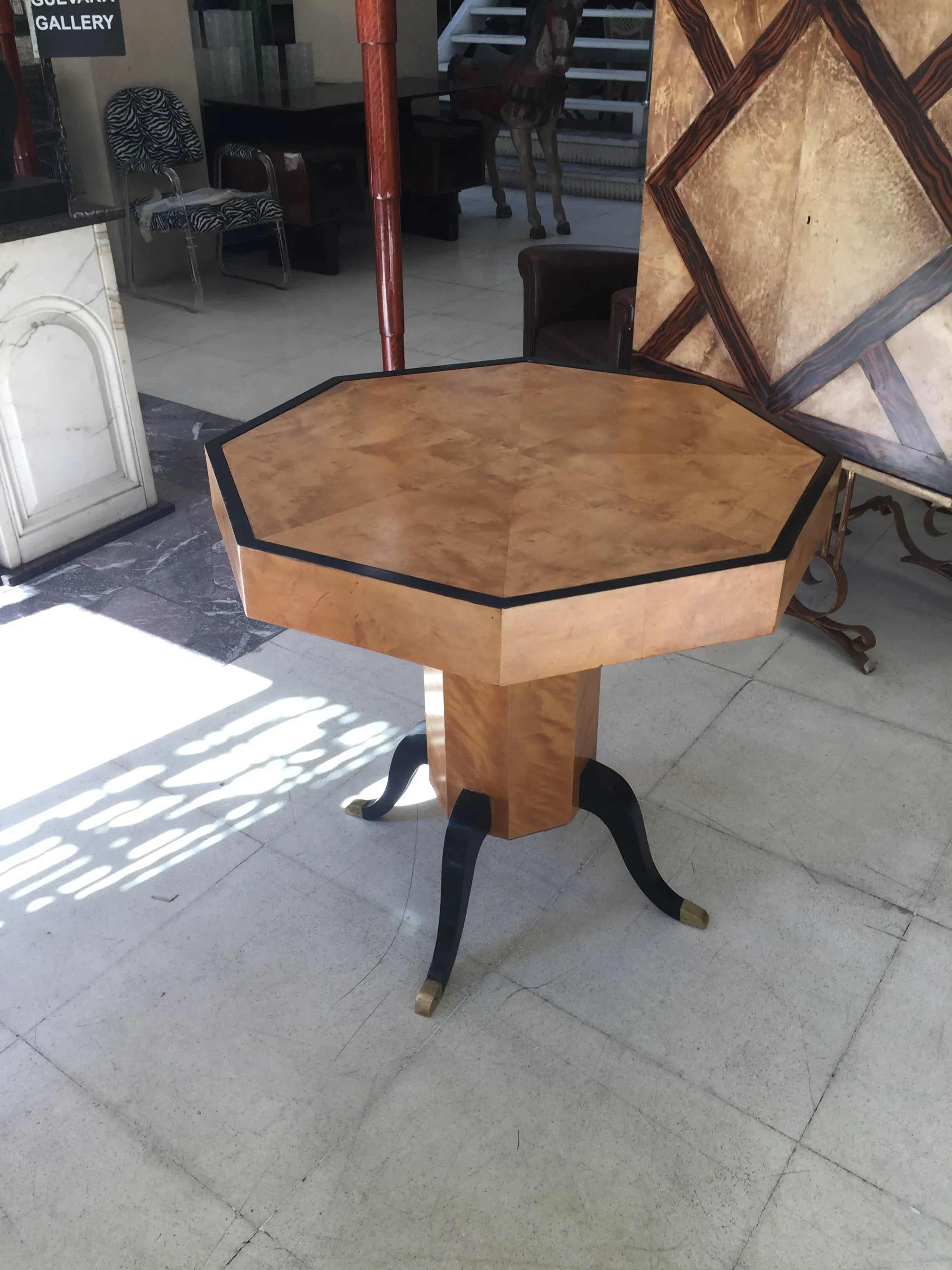 Table octogonale ancienne art deco pour 4 personnes dans un cadre élégant et minimaliste.