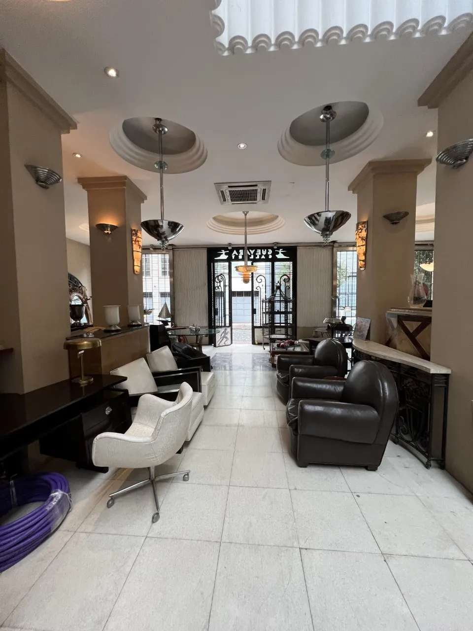 duas lâmpadas de teto antigas em um ambiente elegante com poltronas