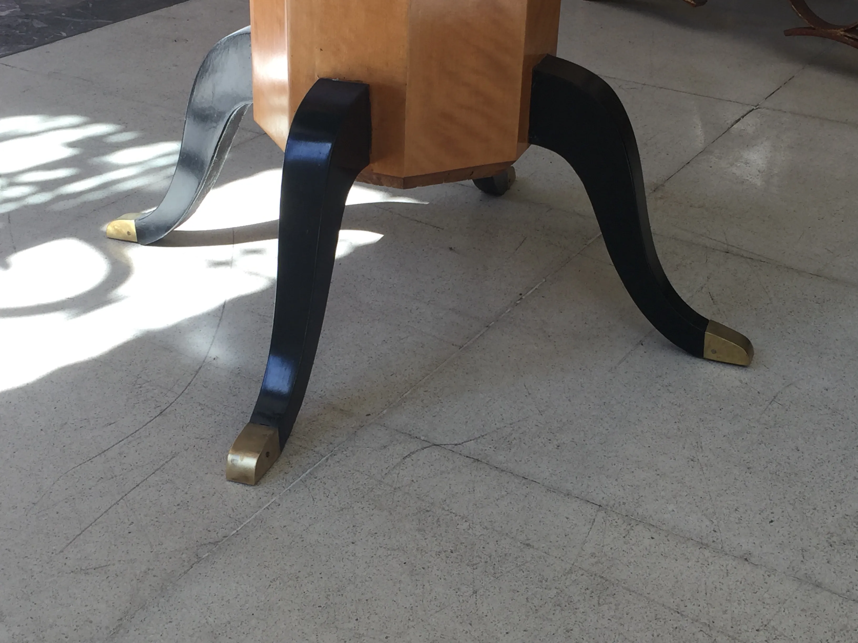 Detail of an antique Art Deco table for 4 people with black and gold legs.