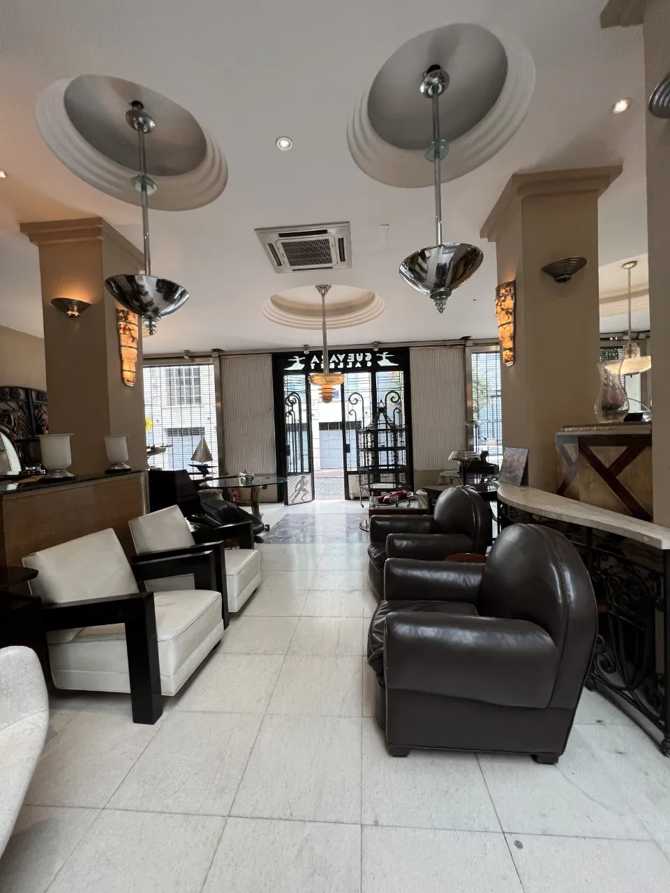 दो पुराने लटकते लैम्प एक आरामदायक कमरे में, आरामदायक कुर्सियों के साथ एक गर्म माहौल में।