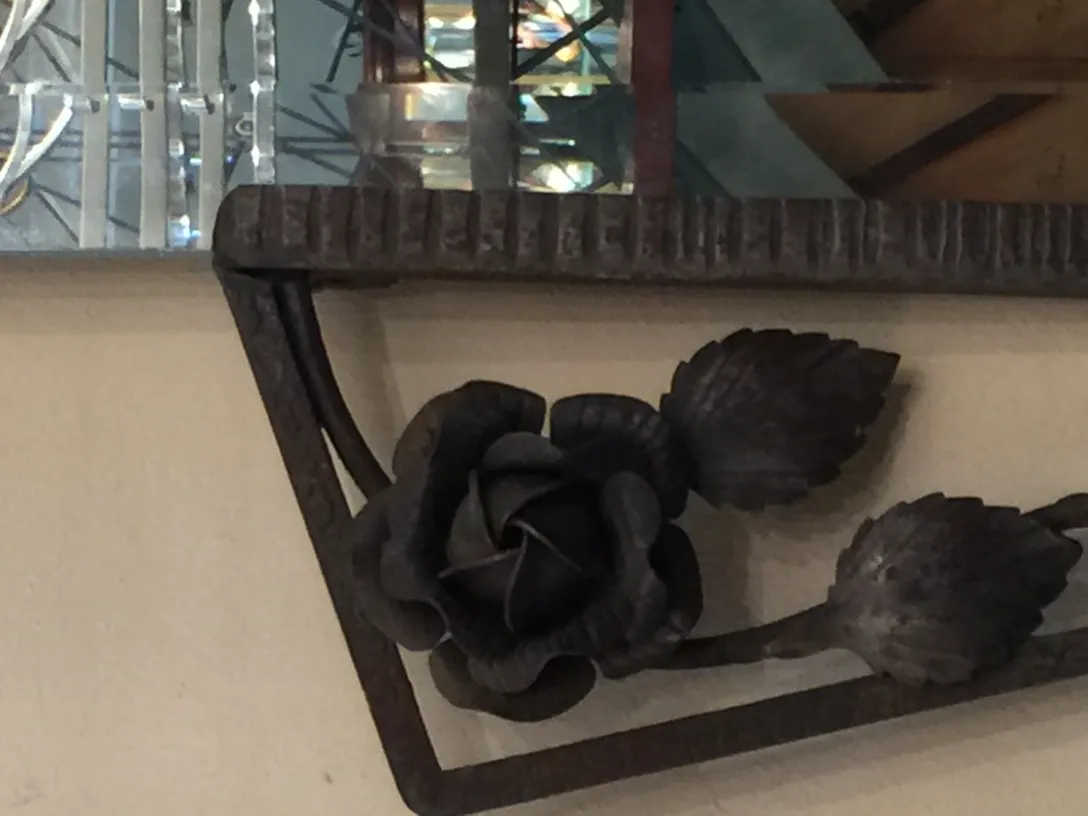 Antique mirror with floral decorations at the bottom.