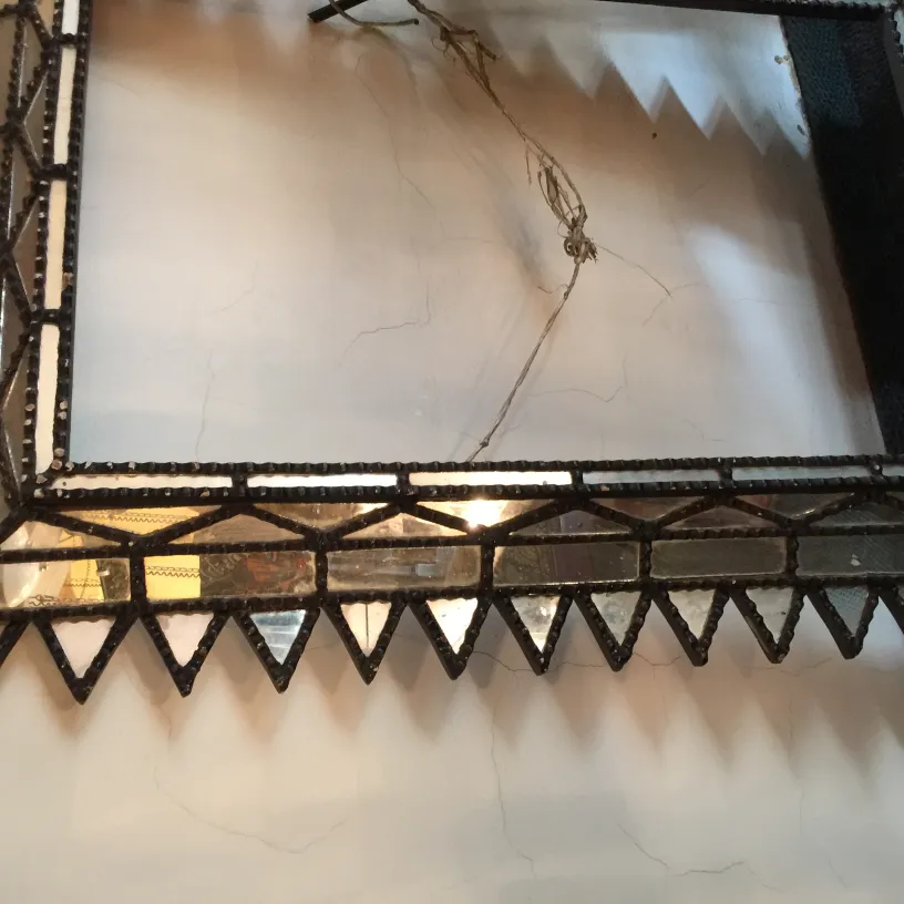espejo antiguo con marco decorativo en forma de triángulos