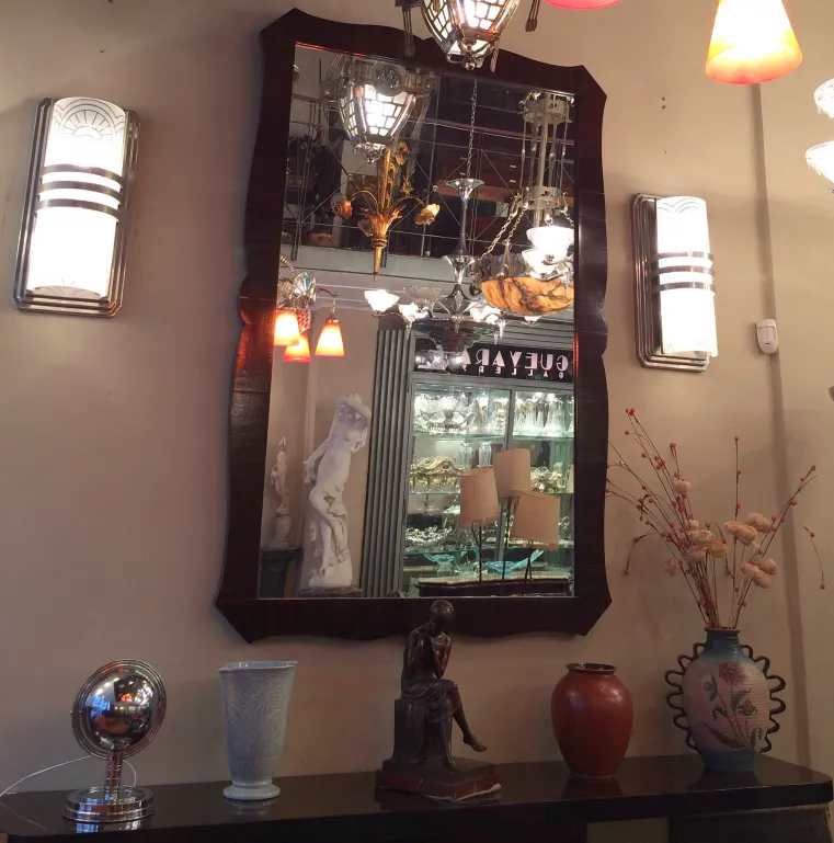 espelho antigo com moldura decorativa em um ambiente elegante com luzes